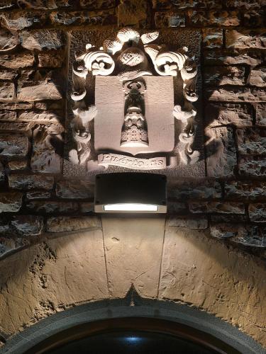 a stone wall with a statue on top of a building at Aparta-Hotel Puertolas in Escuer