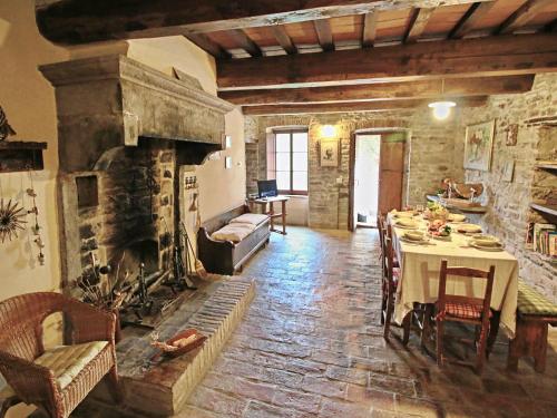 a living room with a table and a fireplace at Farmhouse in Apecchio with Pool and Terrace in Apecchio