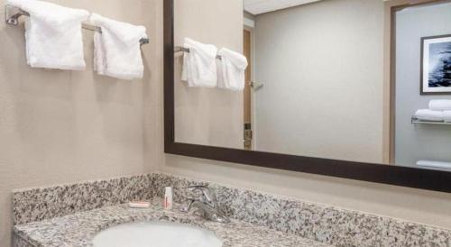 a bathroom with a sink and a large mirror at Days Inn Springfield South in Springfield