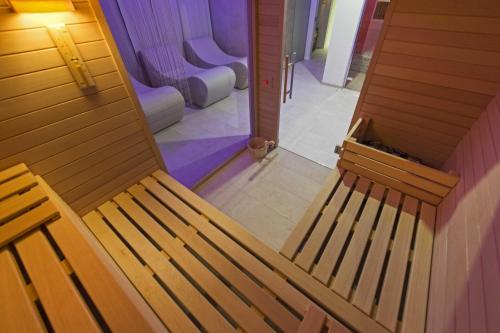 a wooden bench sitting in a room with a hallway at Hotel Monaco in Caorle