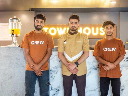 a group of three men standing next to a counter at Sunday Hotel Chandigarh Zirakpur in Zirakpur