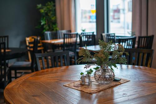 a wooden table with a vase with a plant on it at Northern Light Hotel in Boden