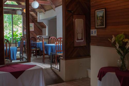 a dining room with tables and chairs in a restaurant at Hotel Villa Zurqui in San José