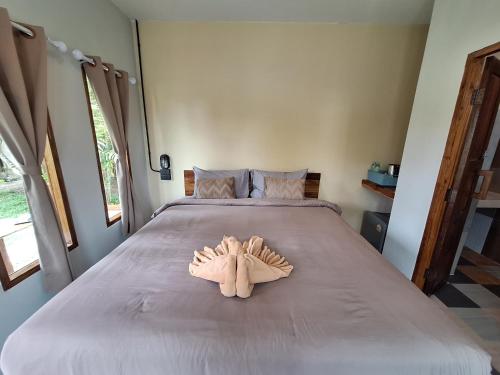 a bed with a pair of mitts on it at The Seasons At Pai in Pai