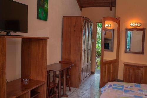 - une chambre avec un lit, un bureau et une télévision dans l'établissement Hotel Villa Zurqui, à San José