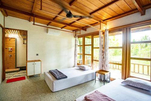 a bedroom with two beds and a large window at Mentawai Balcony in Masokut