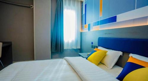 a bedroom with a large bed with colorful pillows at 7 Days Inn Xi'an Railway Station in Xi'an