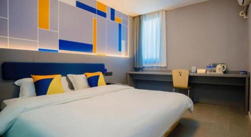 a bedroom with a large bed and a desk at 7 Days Inn Xi'an Railway Station in Xi'an
