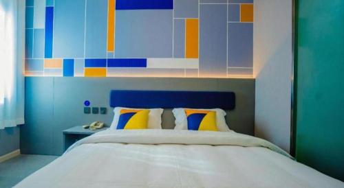 a bedroom with a bed with a blue and colorful wall at 7 Days Inn Xi'an Railway Station in Xi'an
