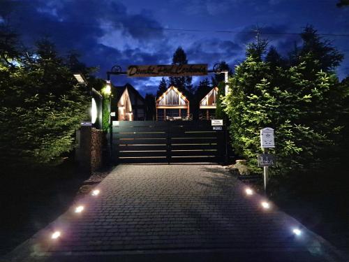 a gate to a house at night with lights at Domki Pod Cerkwią in Komańcza