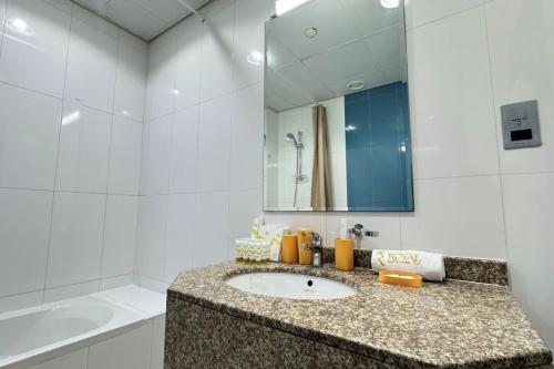 a bathroom with a sink and a mirror at 1BR Al Reem Island - Chic & Serene Luxe Retreat in Abu Dhabi