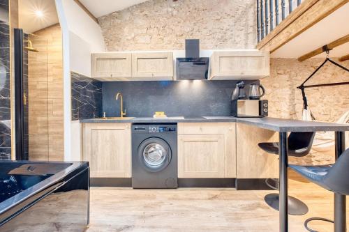 a kitchen with a washing machine and a sink at La bulle étoilée in Périgueux