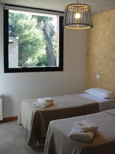 two beds in a room with a large window at Casa Huarpes MDP en Bosque Peralta Ramos in Mar del Plata