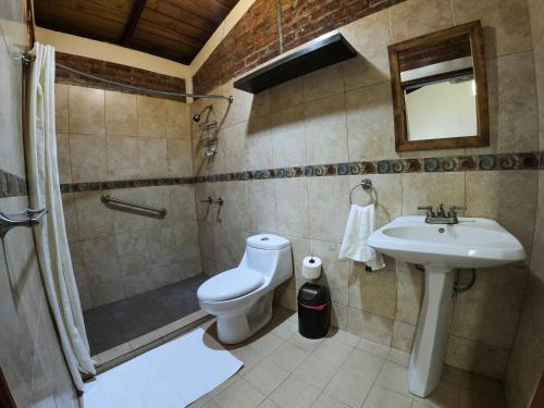 a bathroom with a toilet and a shower and a sink at Congos Lodge in El Perú