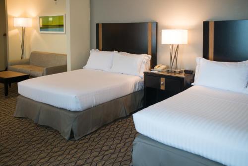 a hotel room with two beds and a chair at Holiday Inn Express Hotel & Suites Chanhassen by IHG in Chanhassen