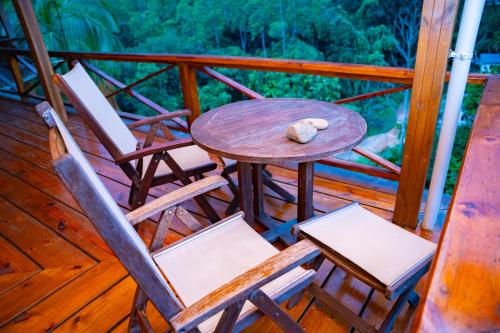 a wooden table and chairs on a porch with a teddy bear at Villa Vanilla in Port Glaud