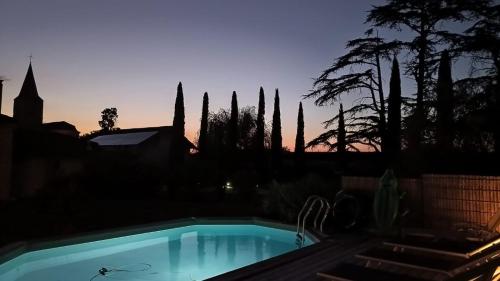 una piscina con un tramonto sullo sfondo di La Métairie du Clos Saint Louis a Montréal