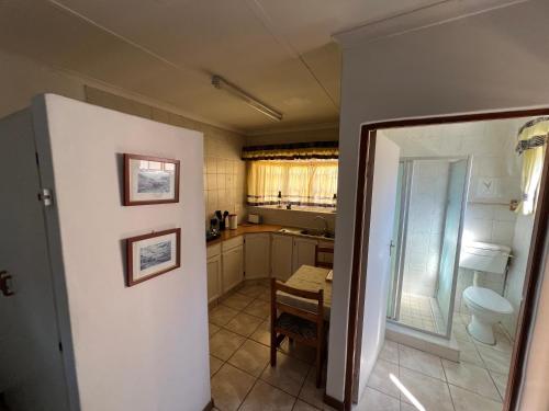 una piccola cucina con servizi igienici e tavolo di Pavlovna Cozy 2 Cottage a Himeville