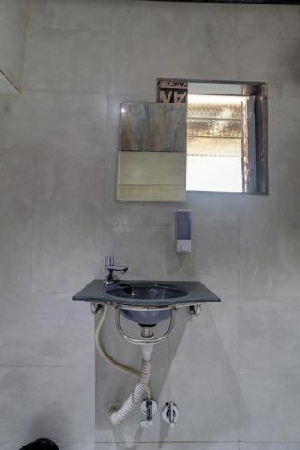 a bathroom with a sink and a mirror at Hotel Platinum Inn in Navi Mumbai