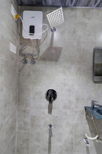 a shower in a bathroom with a machine on the floor at Hotel Platinum Inn in Navi Mumbai