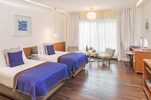 a hotel room with two beds and a desk at The Park New Delhi in New Delhi