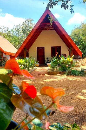 a small house with a red roof at Sigiri Enaya Cottage in Sigiriya
