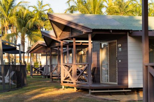 a small cabin with a porch with palm trees at Darwin FreeSpirit Resort in Darwin