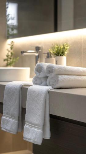 a pile of towels on a counter in a bathroom at Private luxury stay Abudhabi - Check out 2 pm in Abu Dhabi