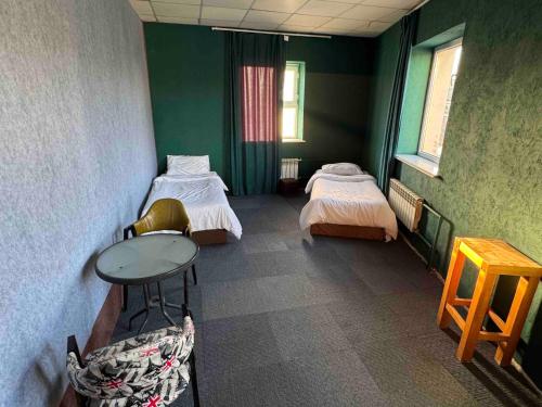 a room with two beds and a table in it at Summer hostel in Ulaanbaatar