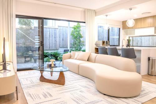 a living room with a couch and a table at CASSA AURA PLACE - Modern 4BR Homes in Brisbane