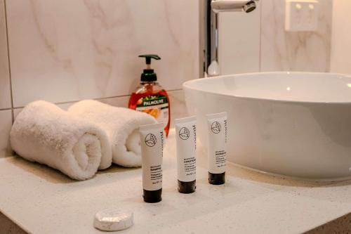 a bathroom counter with three toothbrushes and a sink at CASSA AURA PLACE - Modern 4BR Homes in Brisbane