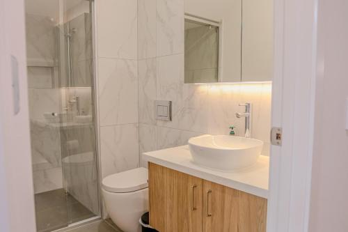 a bathroom with a sink and a toilet and a shower at CASSA AURA PLACE - Modern 4BR Homes in Brisbane