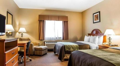 a hotel room with two beds and a desk at Quality Inn in Sidney