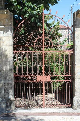 un cancello nero con un albero dietro. di Casa da Eira a Marco de Canaveses