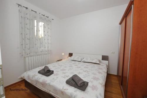 a bedroom with a bed with two towels on it at Apartments Erika & Tai in Sečovlje