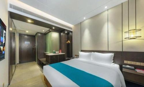 a bedroom with a large bed and a bathroom at H Life Hotel Nanshan Branch in Shenzhen