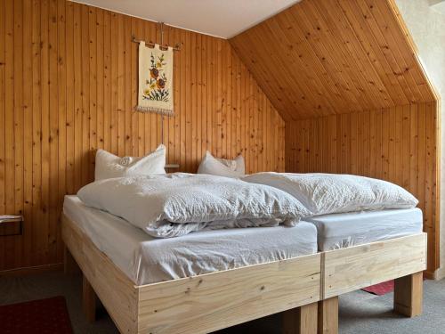 a bed in a room with a wooden wall at Gasthaus zur Grenze in Cuxhaven