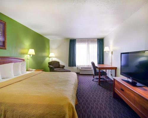 a hotel room with a large bed and a flat screen tv at Quality Inn & Suites Airport in Austin