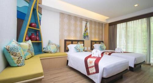 a hotel room with two beds and a window at Phi Phi Nice Beach Hotel Hip in Phi Phi Don