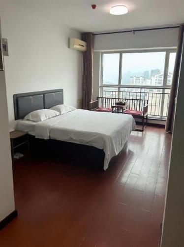 a bedroom with a bed and a balcony at GreenTree Inn Weihai Liugongdao Wharf Qingdao North Road Express Hotel in Weihai