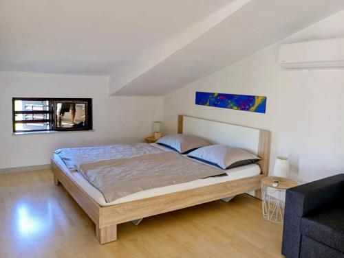 a bedroom with a large bed and a couch at Apartment Marina in Brzac
