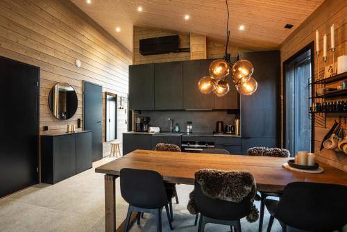 a kitchen with a large wooden table and chairs at Villa Golden Hill Ylläs, Luxury holiday cabin in Lapland in Äkäslompolo