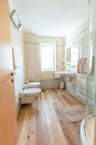 a bathroom with two toilets and a sink at Haus Angelika in Nova Levante