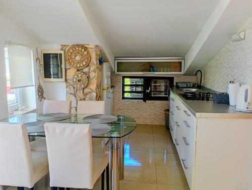 a kitchen with a glass table and white cabinets at Apartment Marina in Brzac