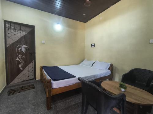 a small bedroom with a bed and a table at Vitamin Sea Beach Front in Gokarn
