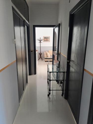 a hallway with two doors and a glass table at The bathers' Home in Nettuno