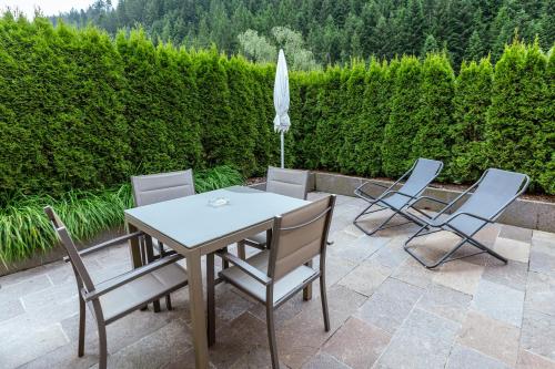 a table and chairs and an umbrella on a patio at Haus Angelika in Nova Levante