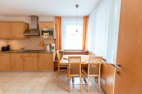 a kitchen with a table and chairs and a window at Haus Angelika in Nova Levante