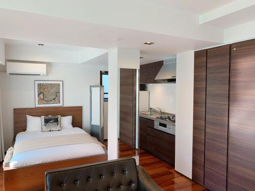a bedroom with a bed and a kitchen at Dash Living Tsukiji in Tokyo