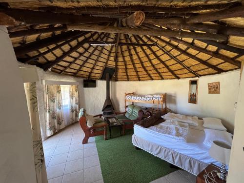 a bedroom with a bed and a wooden ceiling at Pavlovna Bunk with the kids Cottage in Himeville